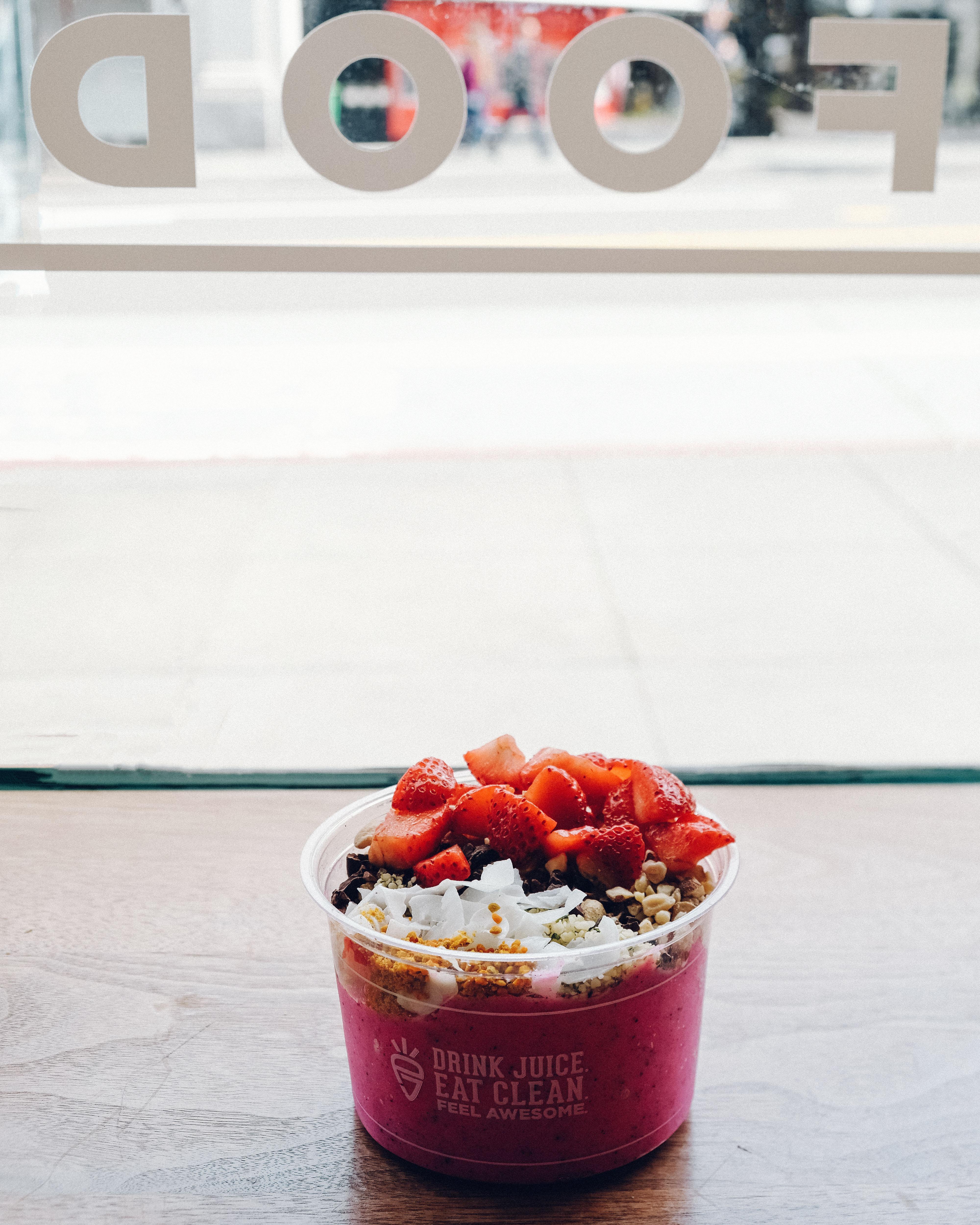 Tigela de açaí com toppings coloridos — granola, frutas e leite condensado — representando combo de açaiteria